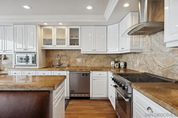 a kitchen with stainless steel appliances granite countertop a stove and cabinets