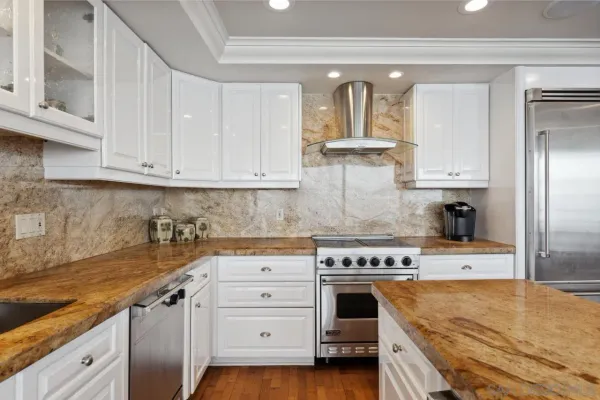 a kitchen that has a lot of cabinets a sink and a stove with wooden floor