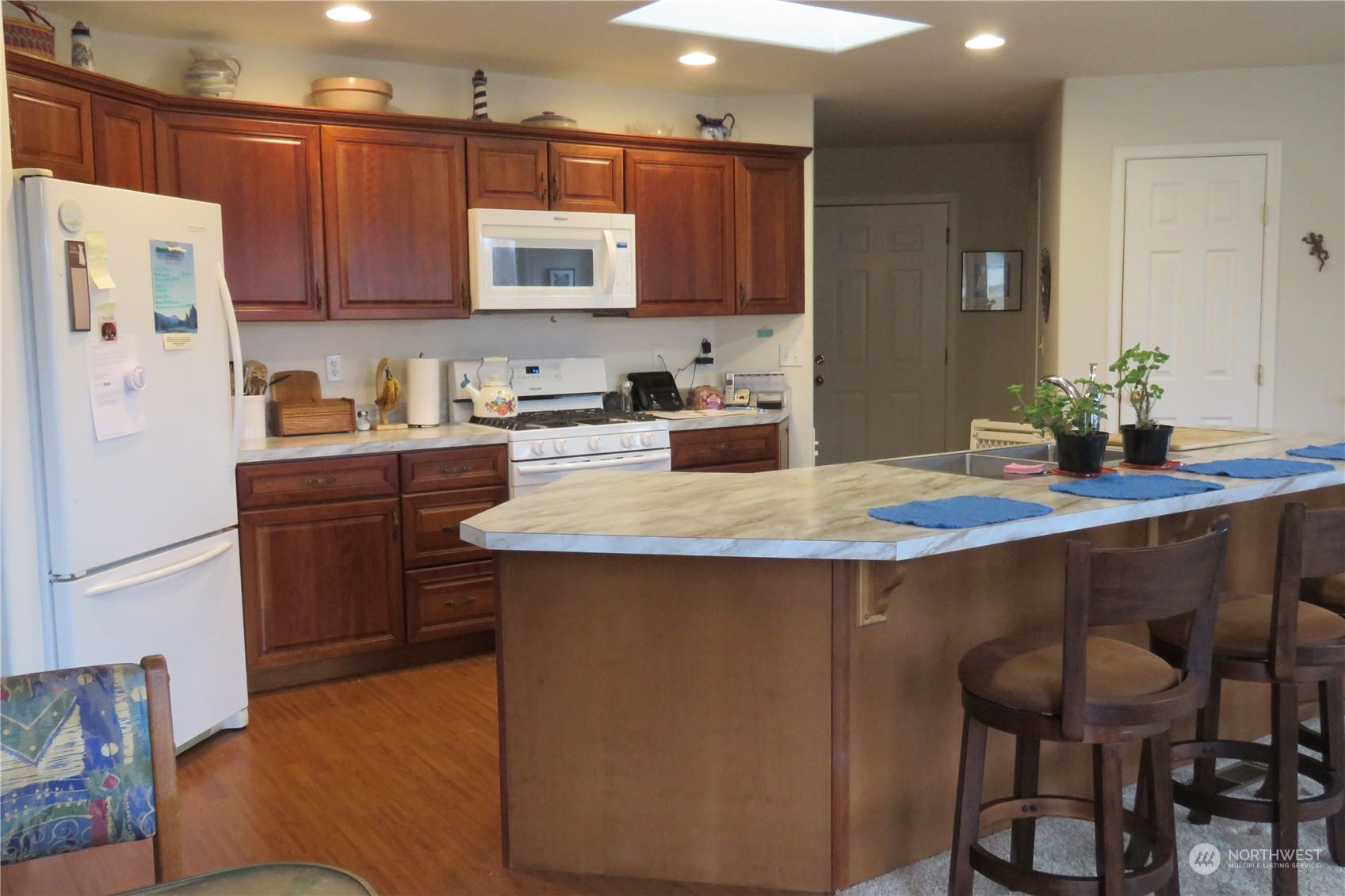 107 South Pass Road, Unit 28 Nooksack, WA 98276 - Photo 5 of 38 a kitchen with granite countertop a table chairs microwave and cabinets