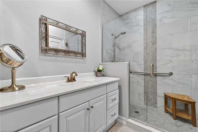 a bathroom with a granite countertop sink a mirror and shower