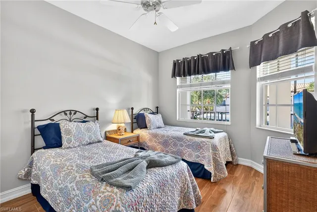 a bedroom with two beds and a flat screen tv