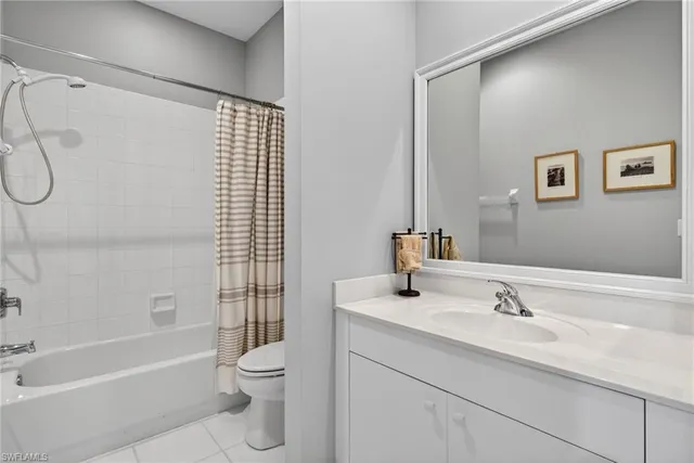 a bathroom with a granite countertop sink a toilet and shower