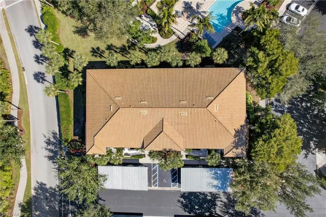 an aerial view of a house with a yard and large trees