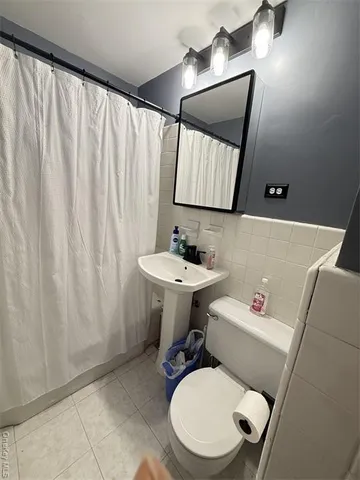 a bathroom with a toilet a sink and a mirror