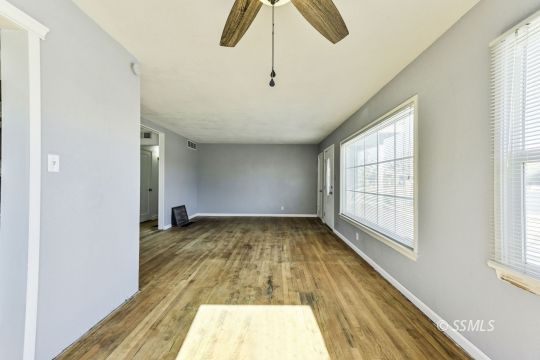 329 North Balsam Street Ridgecrest, CA 93555 - Photo 8 of 27 a view of an empty room with chandelier fan and wooden floor
