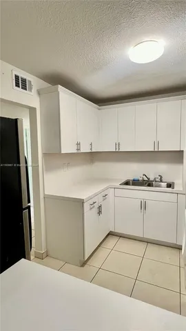 a kitchen with granite countertop white cabinets and stainless steel appliances
