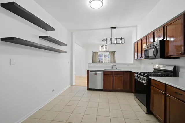 a kitchen with stainless steel appliances granite countertop a sink and stove top oven with wooden floor