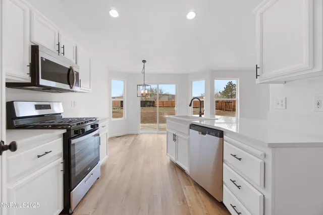 a large kitchen with stainless steel appliances granite countertop a stove and a sink