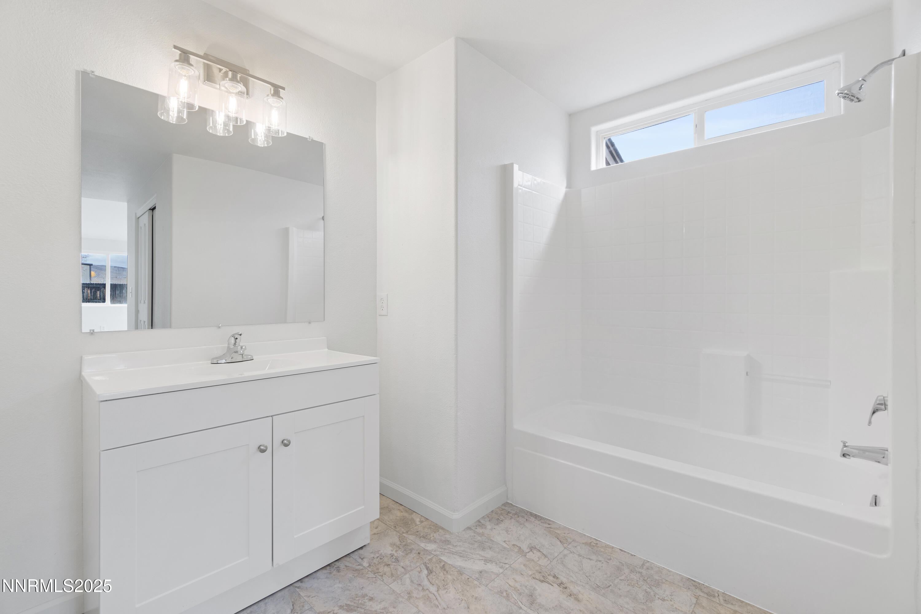 123 Shadow Mountain Drive Fernley, NV 89408 - Photo 25 of 28 a bathroom with a bathtub a sink a vanity and a mirror