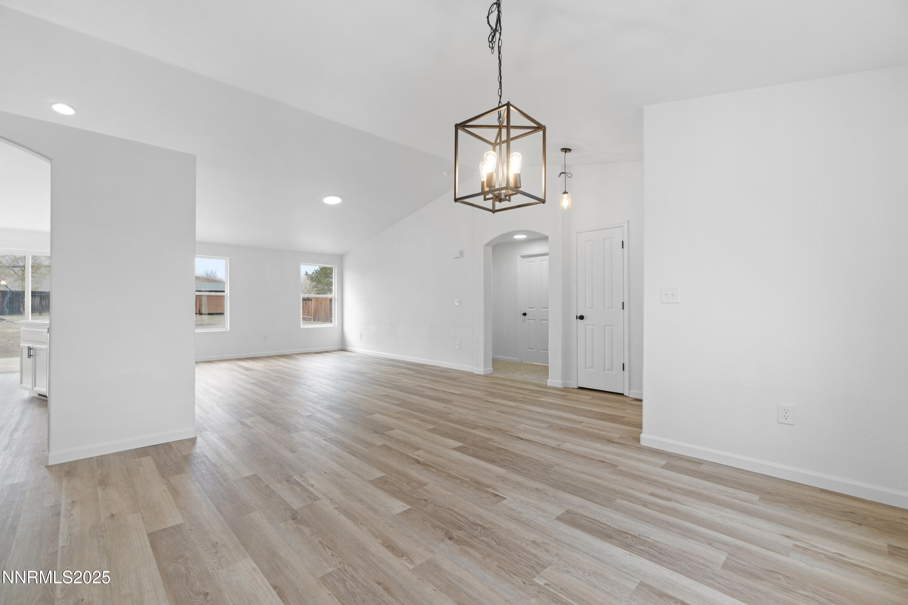 123 Shadow Mountain Drive Fernley, NV 89408 - Photo 7 of 28 a view of empty room with wooden floor and kitchen view