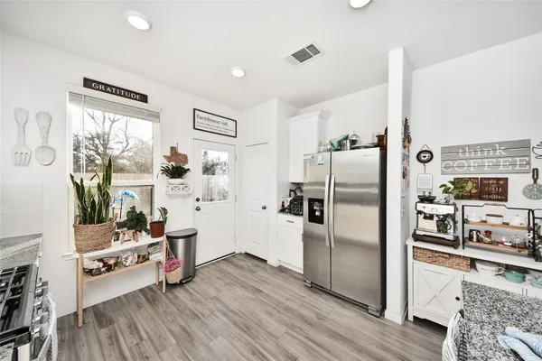 a kitchen with stainless steel appliances a refrigerator and wooden floor