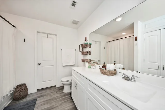 a bathroom with double vanity sinks a mirror and a toilet
