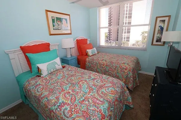 a bedroom with two beds and a chair