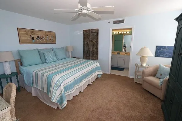 a spacious bedroom with a bed and a chandelier