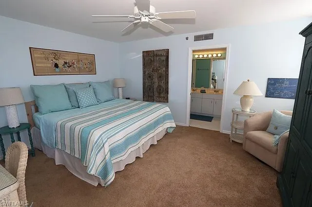 a spacious bedroom with a bed and a chandelier