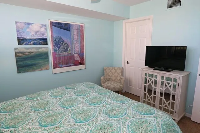 a bedroom with a flat screen tv and a bed