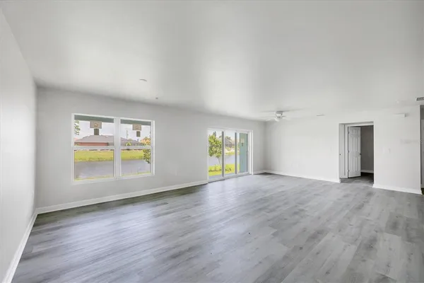 a kitchen that has a sink a refrigerator a stove and white cabinets with wooden floor