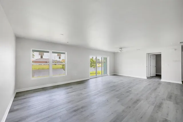 a kitchen that has a sink a refrigerator a stove and white cabinets with wooden floor