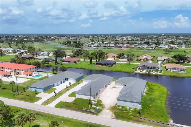 an aerial view of a house with a garden and lake view