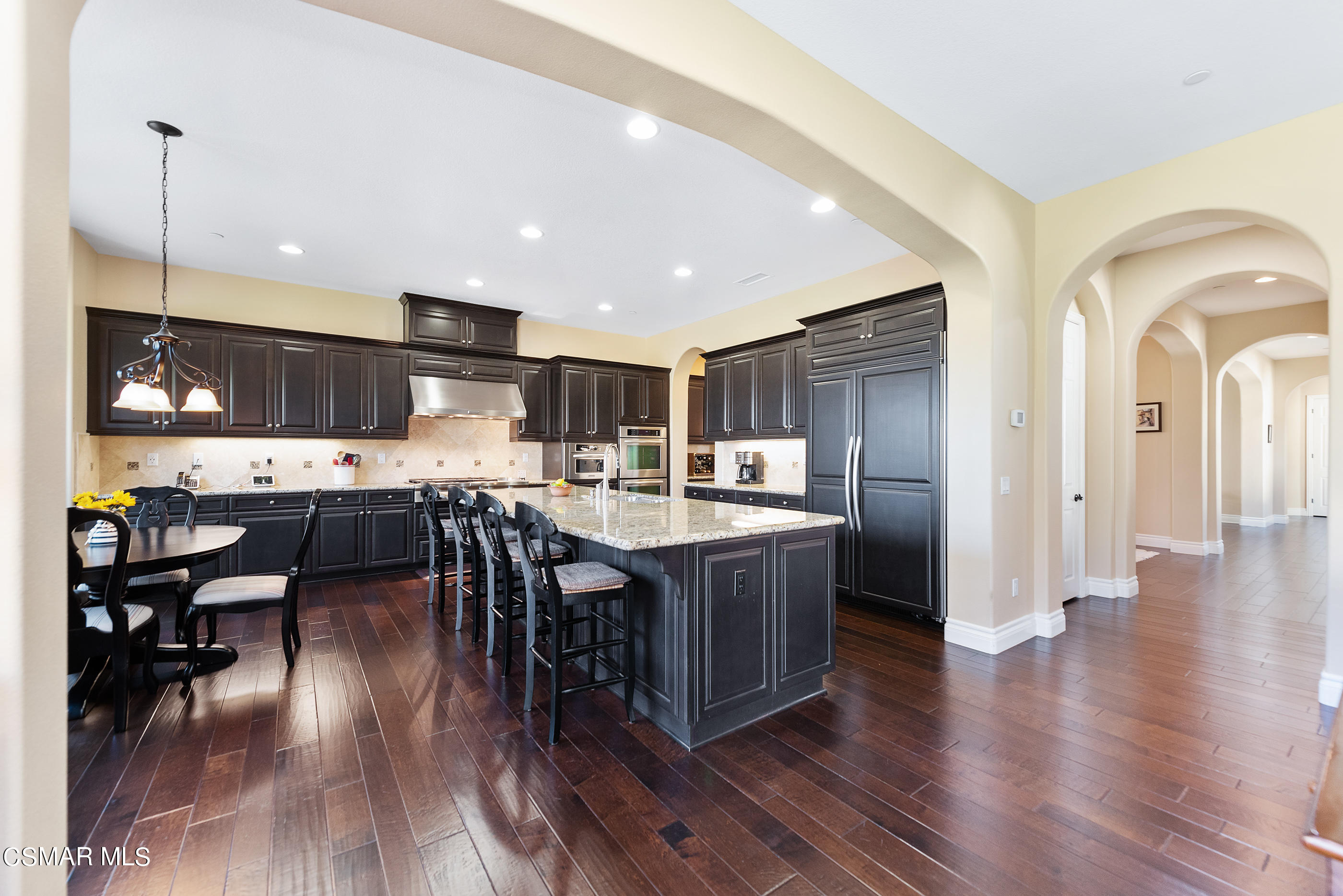 13740 Pinefield Court Moorpark, CA 93021 - Photo 14 of 62 a kitchen with stainless steel appliances granite countertop a refrigerator a stove top oven a sink dishwasher and a dining table with wooden floor