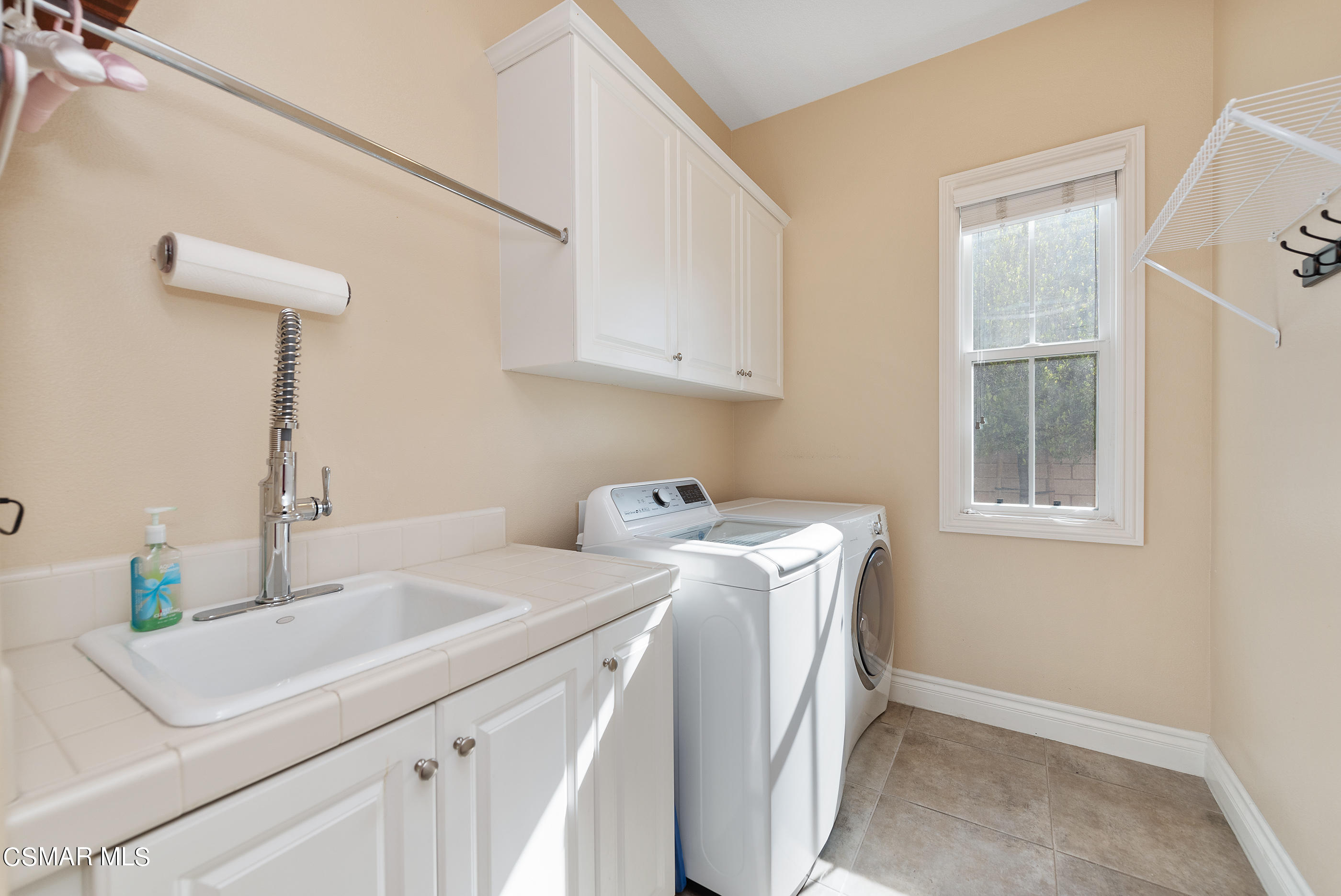 13740 Pinefield Court Moorpark, CA 93021 - Photo 23 of 62 a utility room with cabinets washer and dryer