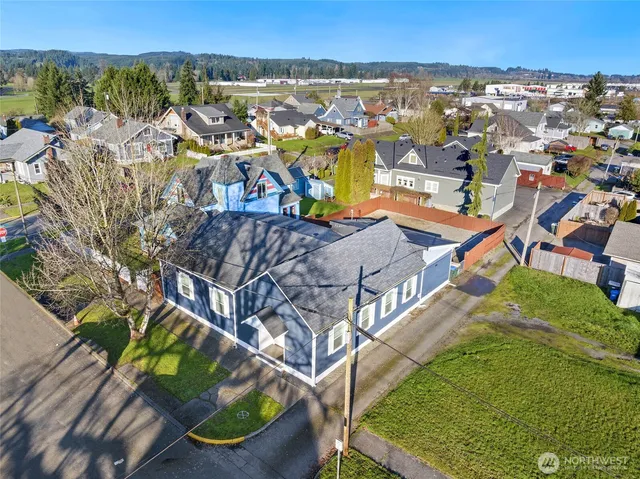 an aerial view of residential houses with outdoor space and trees