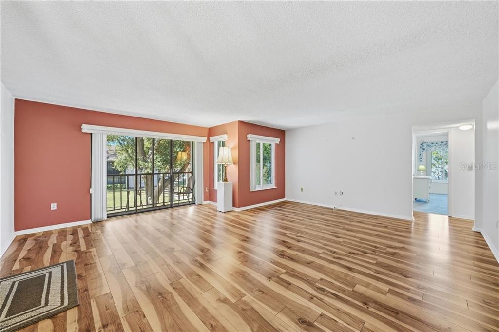 2666 Pine Ridge Way North, Unit C2 Palm Harbor, FL 34684 - Photo 11 of 74 a view of a big room with wooden floor and windows
