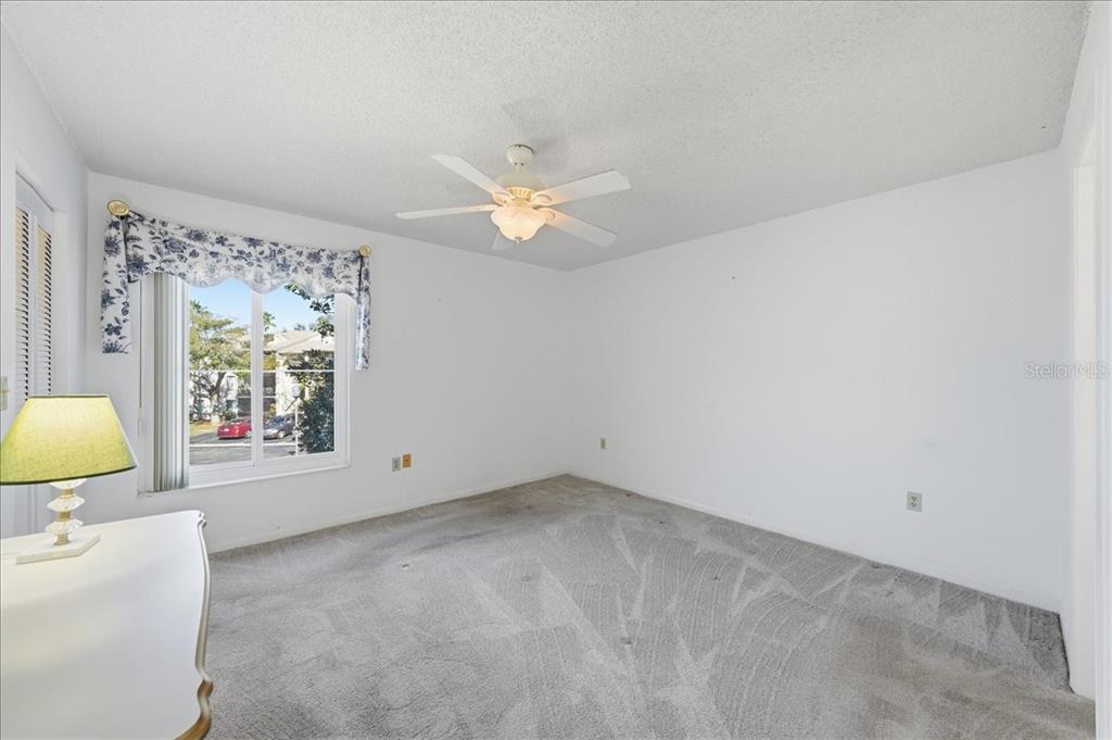 2666 Pine Ridge Way North, Unit C2 Palm Harbor, FL 34684 - Photo 29 of 74 an empty room with a window and a ceiling fan