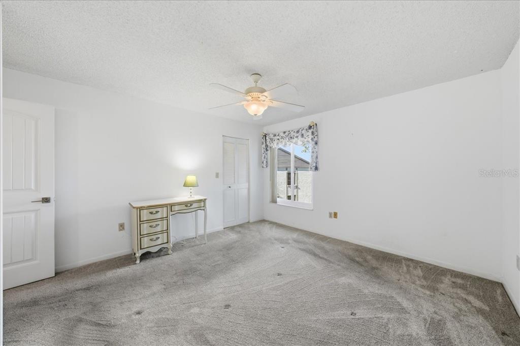 2666 Pine Ridge Way North, Unit C2 Palm Harbor, FL 34684 - Photo 31 of 74 an empty room with windows and fan