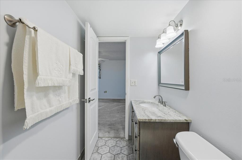 2666 Pine Ridge Way North, Unit C2 Palm Harbor, FL 34684 - Photo 34 of 74 a bathroom with a granite countertop sink a toilet and shower