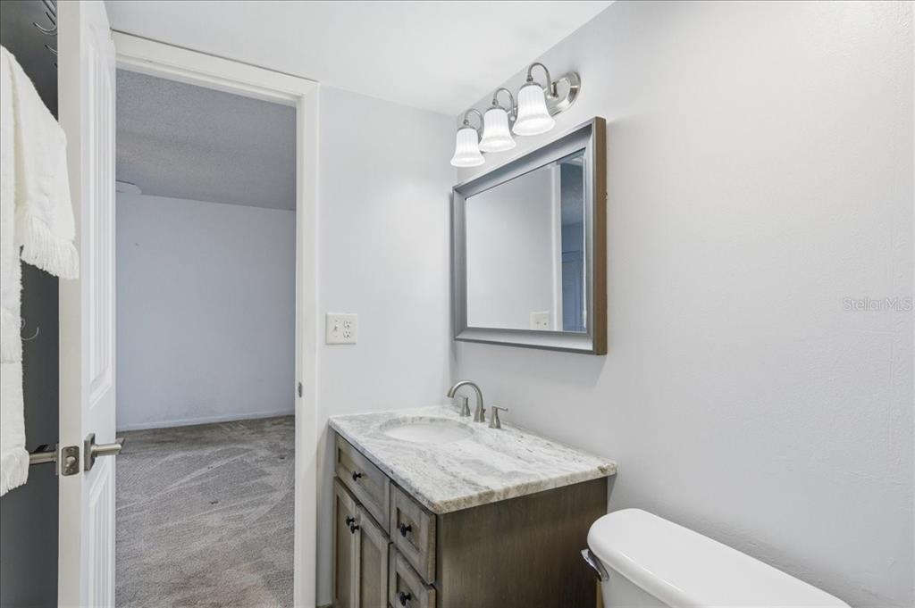 2666 Pine Ridge Way North, Unit C2 Palm Harbor, FL 34684 - Photo 35 of 74 a bathroom with a granite countertop sink toilet and mirror