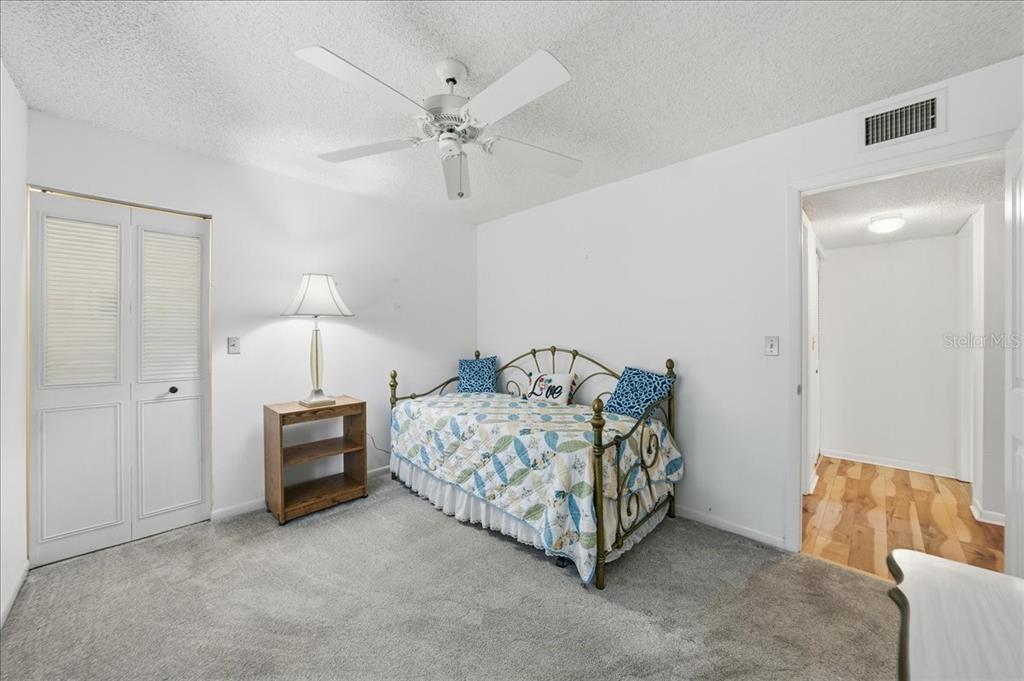 2666 Pine Ridge Way North, Unit C2 Palm Harbor, FL 34684 - Photo 37 of 74 a bed room with a bed and a chandelier