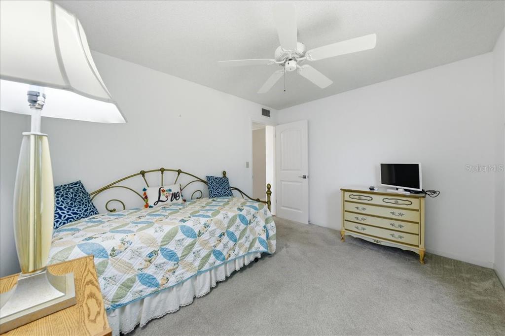 2666 Pine Ridge Way North, Unit C2 Palm Harbor, FL 34684 - Photo 38 of 74 a bedroom with a bed and a chandelier