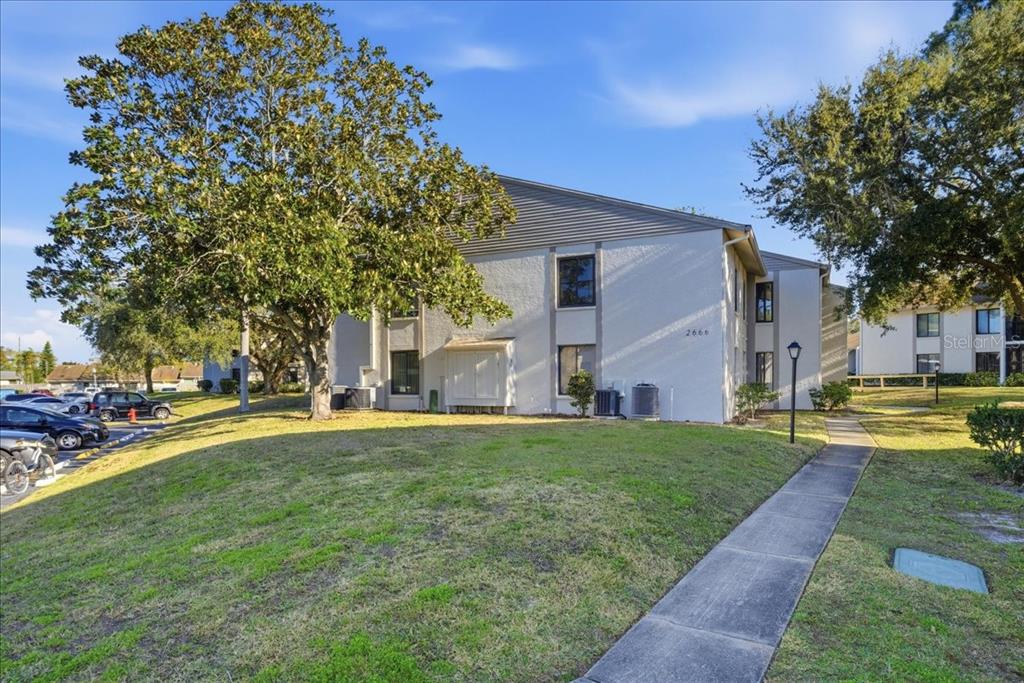 2666 Pine Ridge Way North, Unit C2 Palm Harbor, FL 34684 - Photo 49 of 74 a front view of a house with a garden
