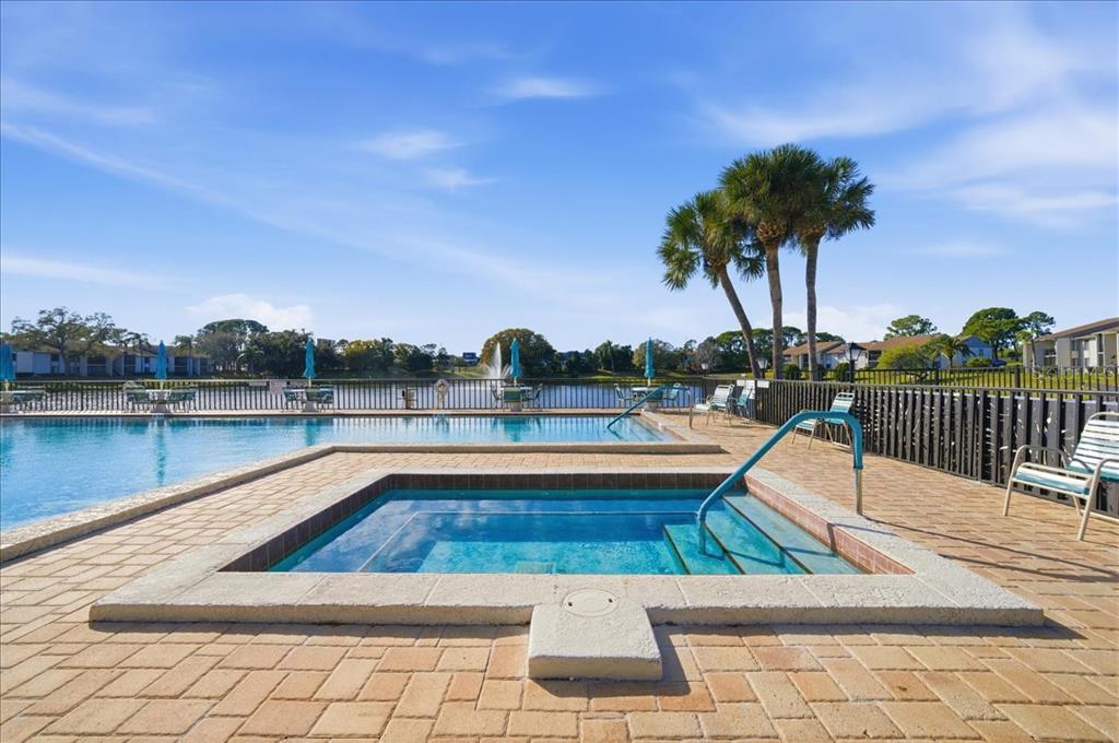 2666 Pine Ridge Way North, Unit C2 Palm Harbor, FL 34684 - Photo 55 of 74 a view of a swimming pool with a lounge chairs