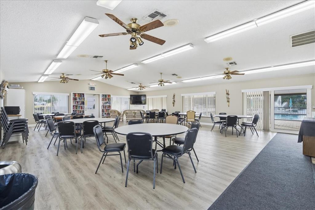 2666 Pine Ridge Way North, Unit C2 Palm Harbor, FL 34684 - Photo 64 of 74 a view of a dining room and livingroom with lots of furniture and a large window