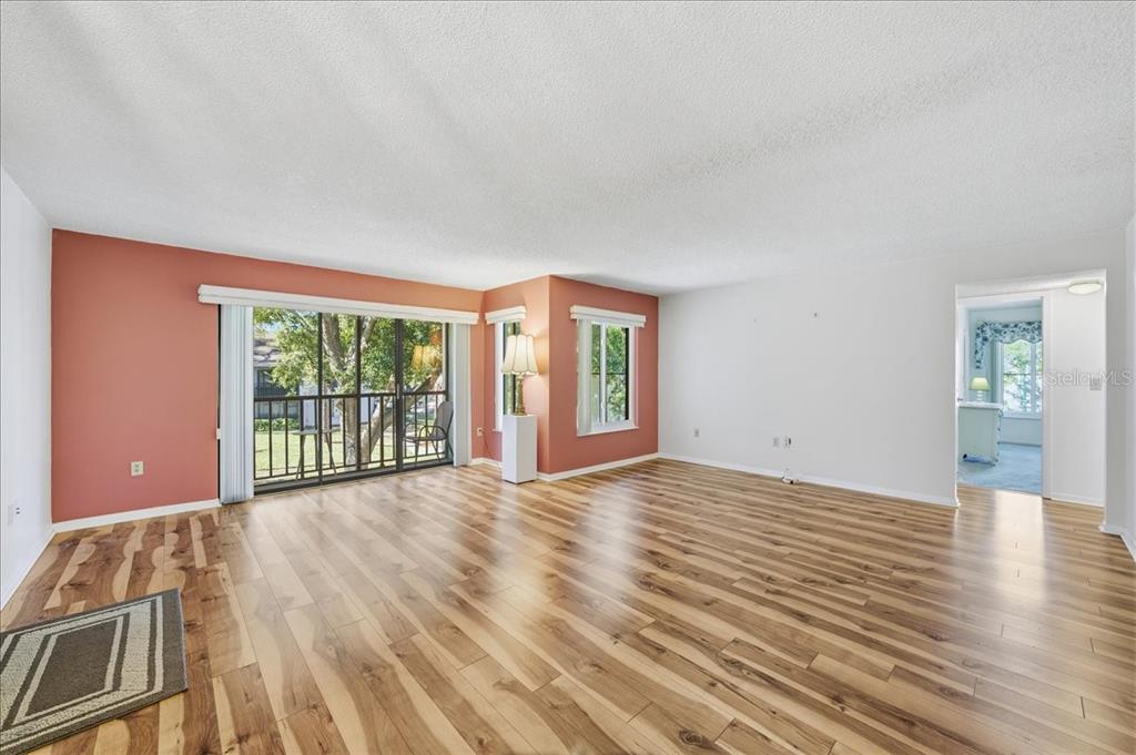 2666 Pine Ridge Way North, Unit C2 Palm Harbor, FL 34684 - Photo 7 of 74 a view of an empty room with wooden floor and a window