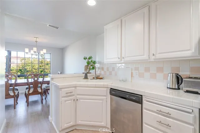 a kitchen with white cabinets and sink