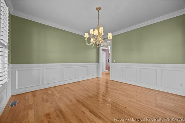 a view of a room with wooden floor and chandelier