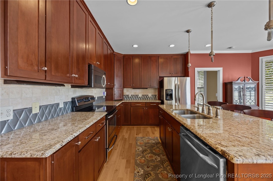 8224 Highway 210 Angier, NC 27501 - Photo 38 of 50 a kitchen with granite countertop kitchen island stainless steel appliances a sink a stove a refrigerator a sink a refrigerator with wooden cabinets