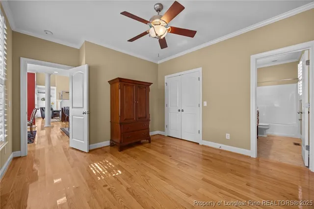 a view of a livingroom with a chandelier fan and a kitchen space