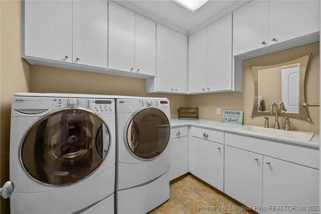 a utility room with sink dryer and washer