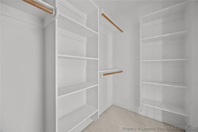 a view of walk in closet with empty racks