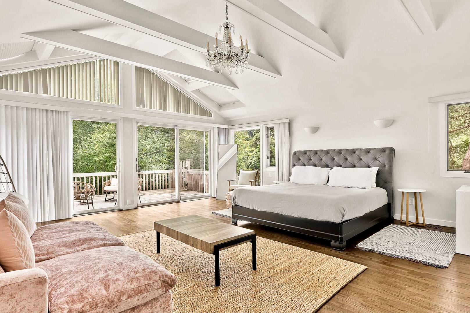 29 Petrel Road Southampton, NY 11968 - Photo 14 of 28 a spacious bedroom with a bed a table and large windows