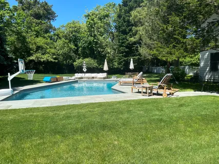 a view of a swimming pool with chairs in the garden