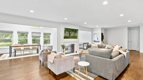 a living room with furniture and floor to ceiling windows