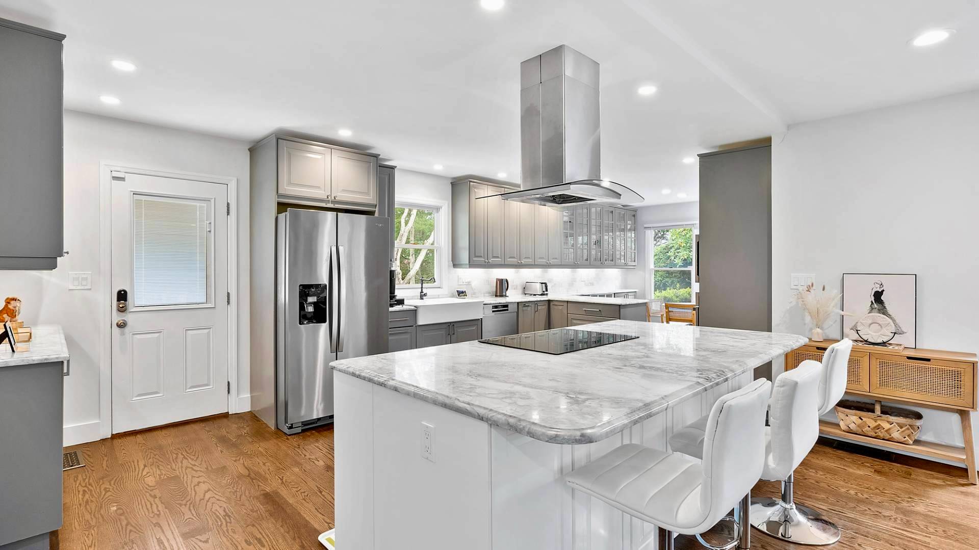 29 Petrel Road Southampton, NY 11968 - Photo 7 of 28 a kitchen with stainless steel appliances a dining table chairs refrigerator and stove