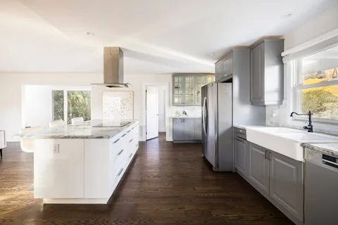 a large bathroom with a granite countertop double vanity sink a bathtub and window