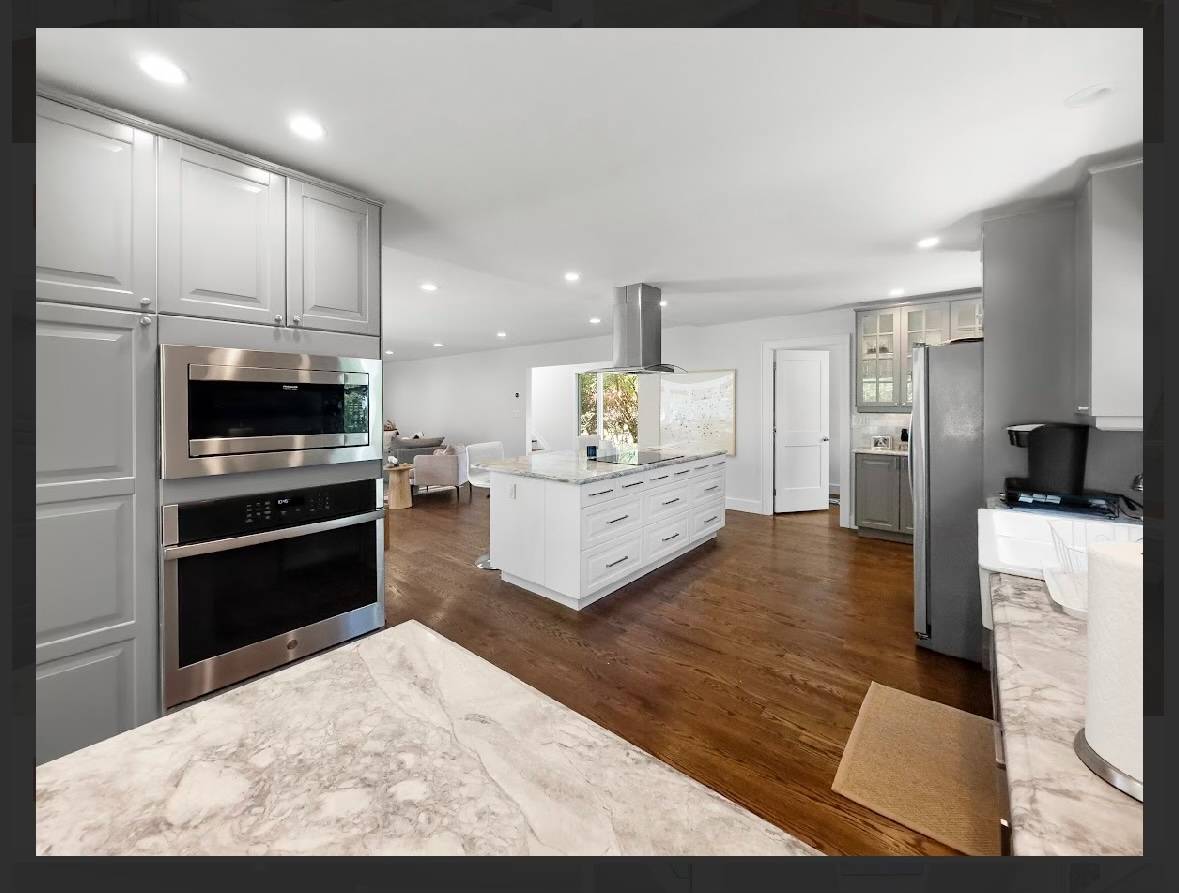 29 Petrel Road Southampton, NY 11968 - Photo 10 of 28 a kitchen with stainless steel appliances kitchen island granite countertop a refrigerator oven a stove with white cabinets