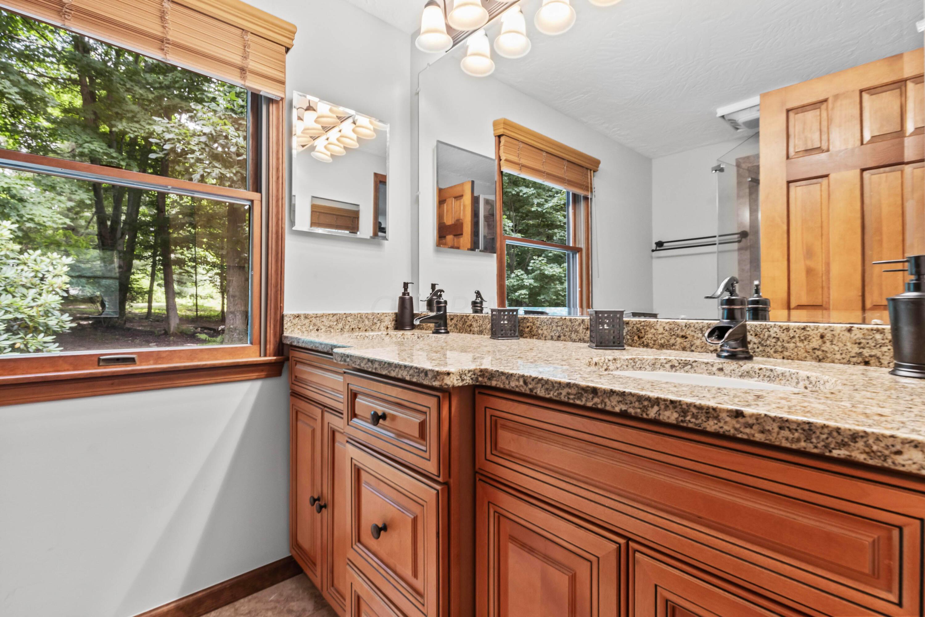 6940 Graham Road Mount Vernon, OH 43050 - Photo 9 of 70 • Grouted vinyl
flooring
• Ivory painted walls
• Enclosed vanity with
double bowl, granite
sinktop
• 6 bulb wall light
• (2) mirrored medicine
cabinets
• Shower stall with glass
enclosure & fiberglass surround
• Lighted ceiling exhaust